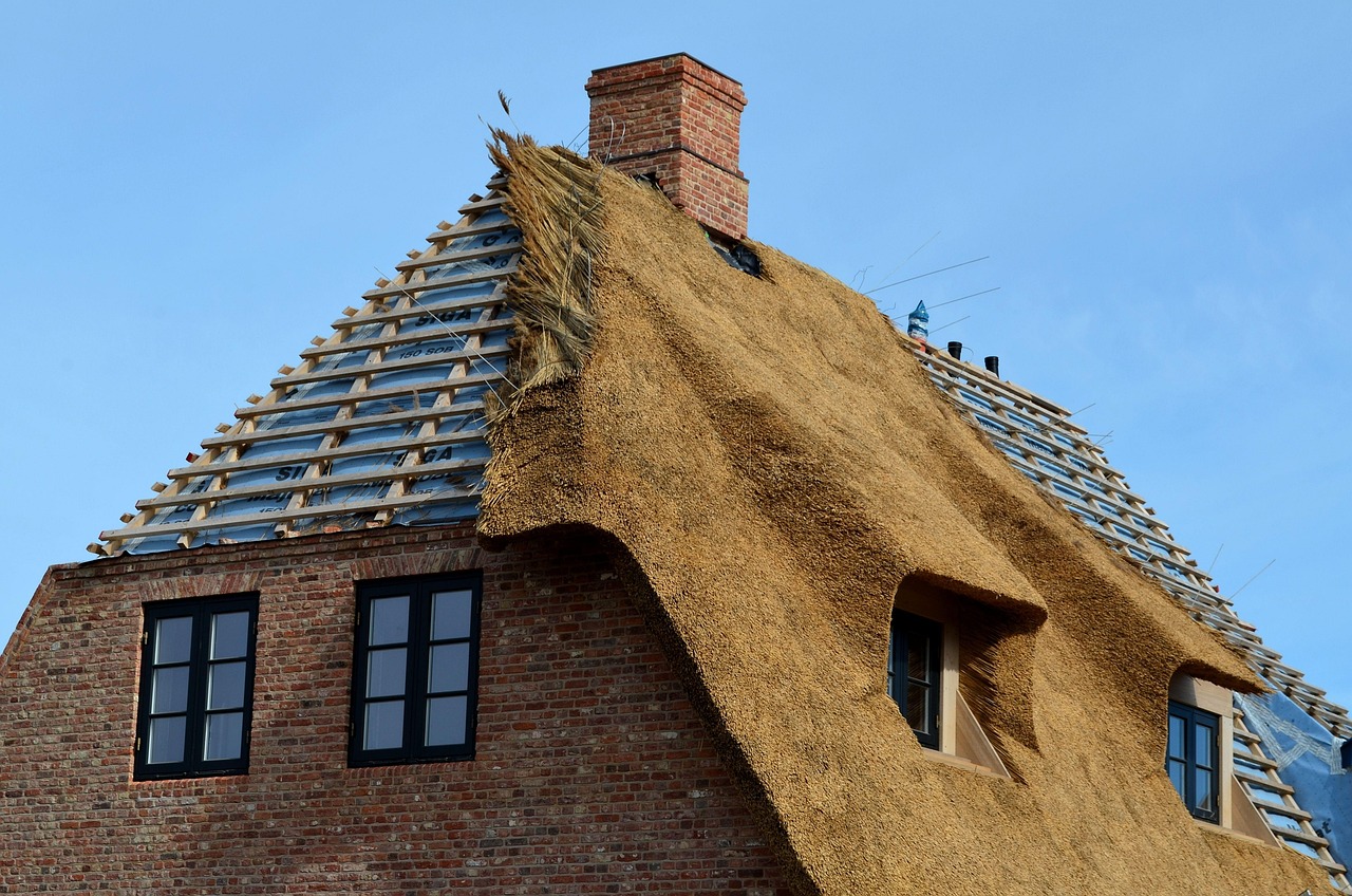 Skilled roofer working on a traditional thatched roof